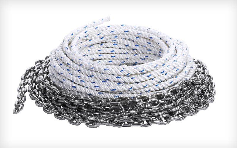 Een opgerolde witte ankerlijn met blauwe markeringen ligt naast een zware metalen ankerketting. Beide zijn netjes opgestapeld en dienen voor het veilig vastleggen van boten. Een opgerolde witte ankerlijn met blauwe markeringen ligt naast een zware metalen ankerketting. Beide zijn netjes opgestapeld en dienen voor het veilig vastleggen van boten.